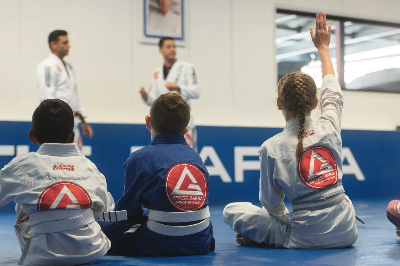 Gracie Barra kids sitting on the mats during a Brazilian Jiu-Jitsu class